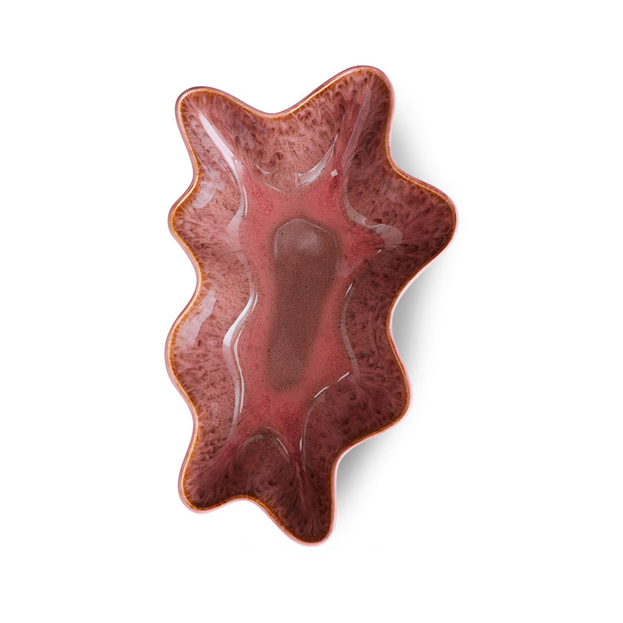 Wavy red ceramic dish on a white background