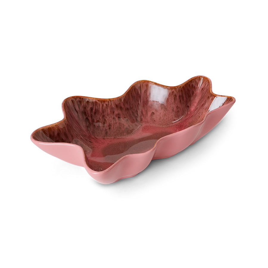 Pink ceramic bowl with wavy edge on a white background