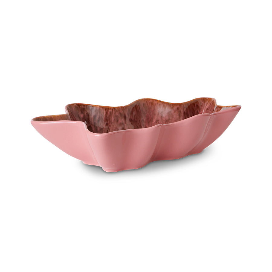 Pink ceramic bowl with wavy edge on a white background