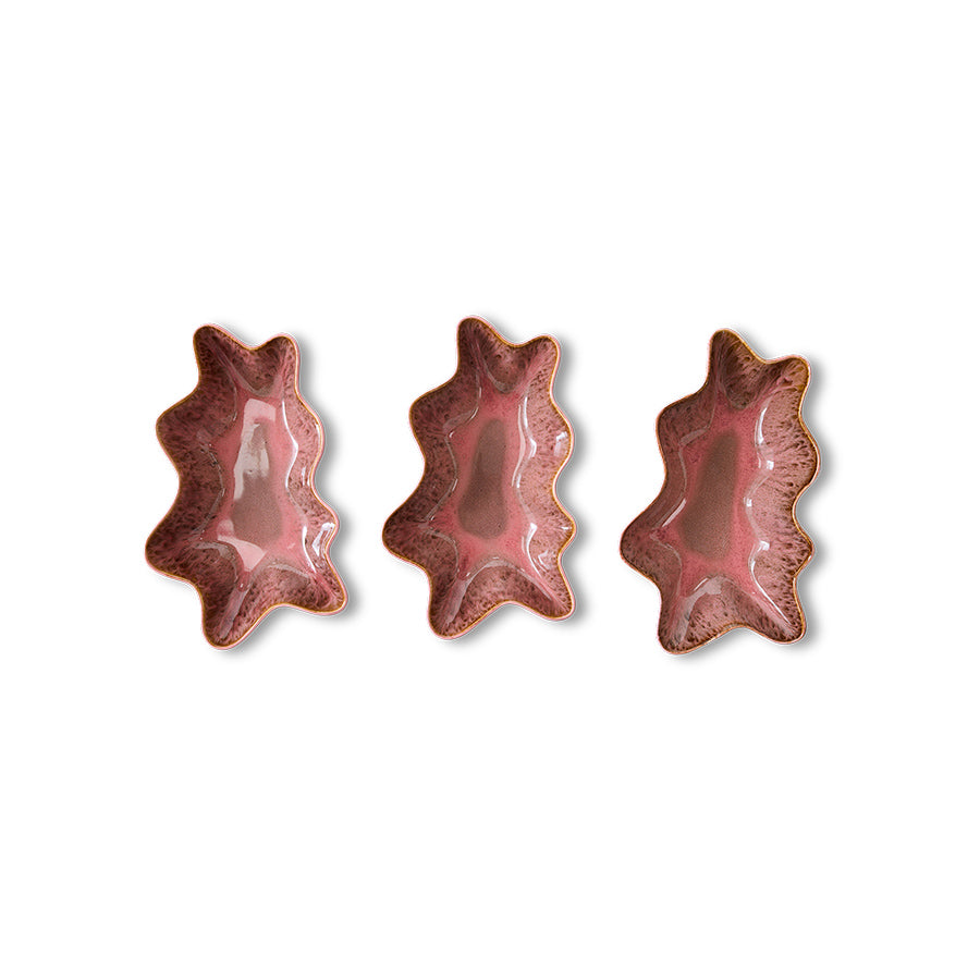 Three pink ceramic leaf-shaped dishes on a white background