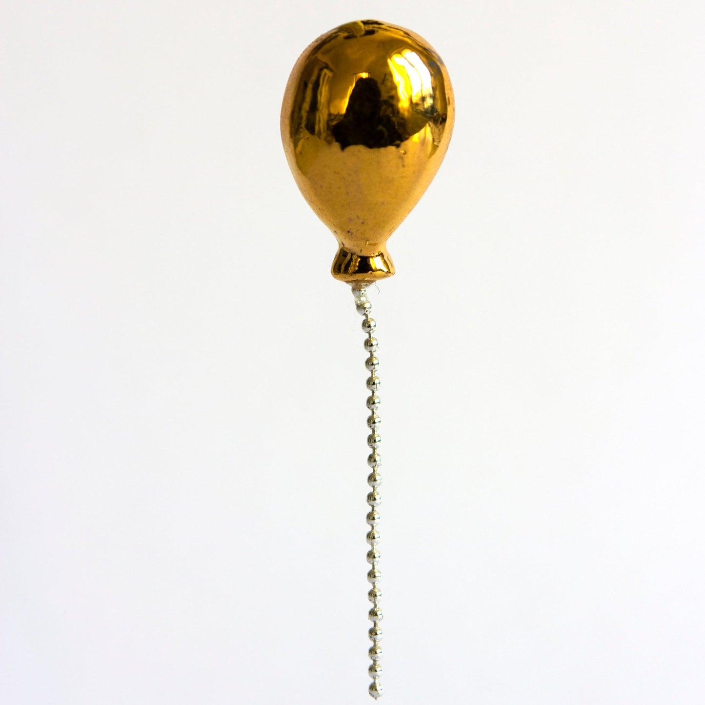 gold colored balloon pin made from porcelain