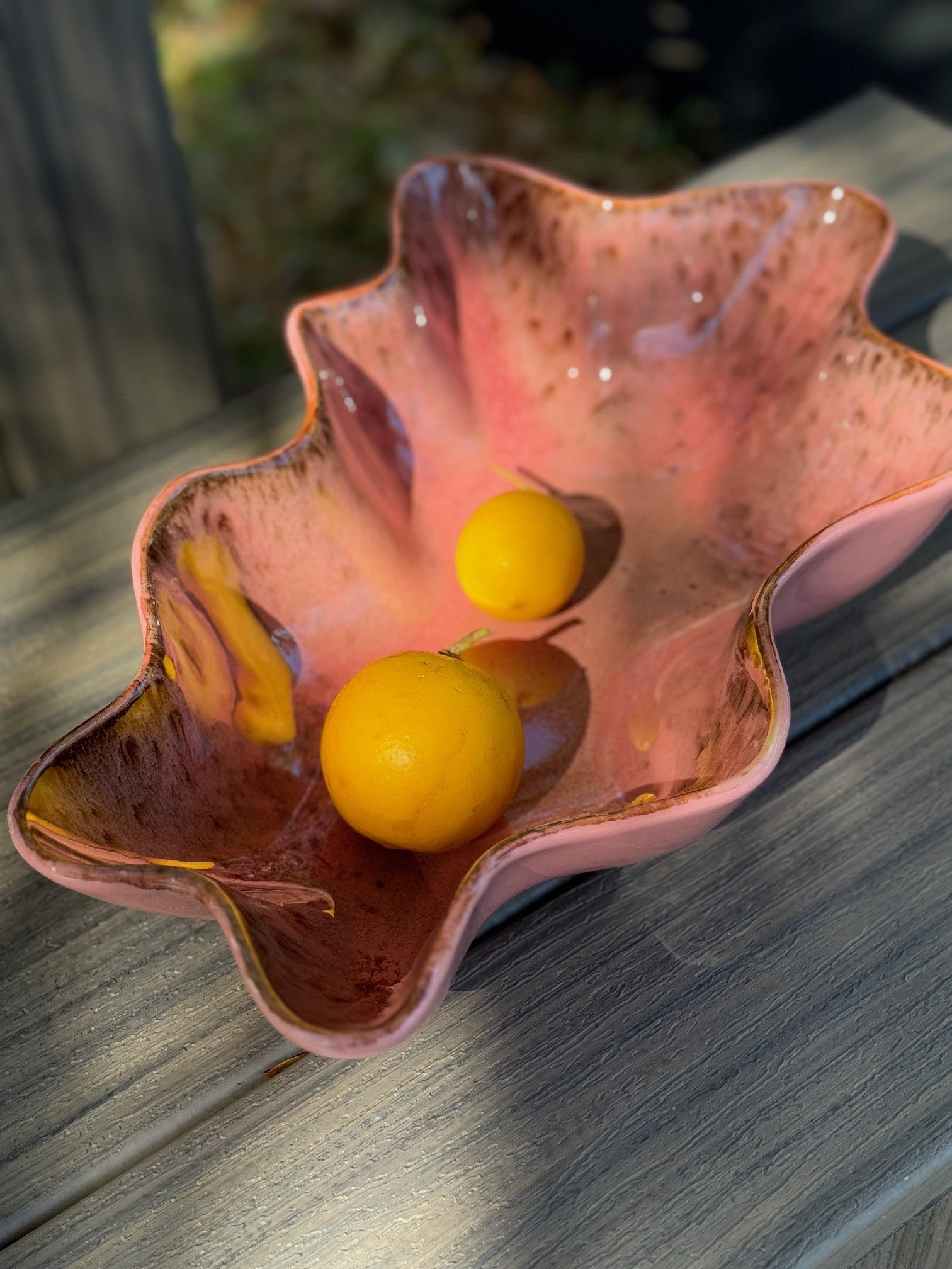 coral deep bowl with lemons on a grey surface