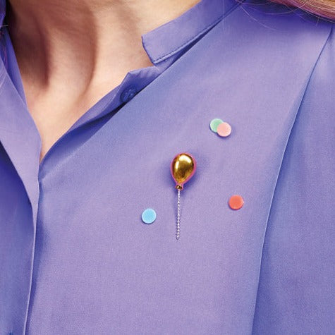 purple blouse with gold color balloon pin