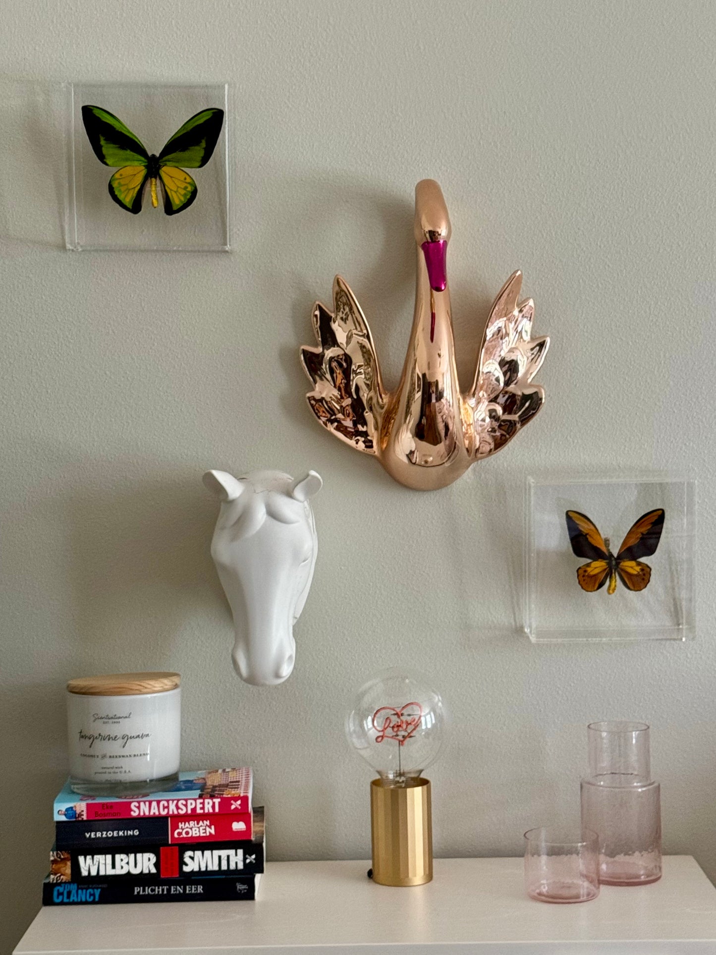 two mounted butterflies hanging among other wall decor. 