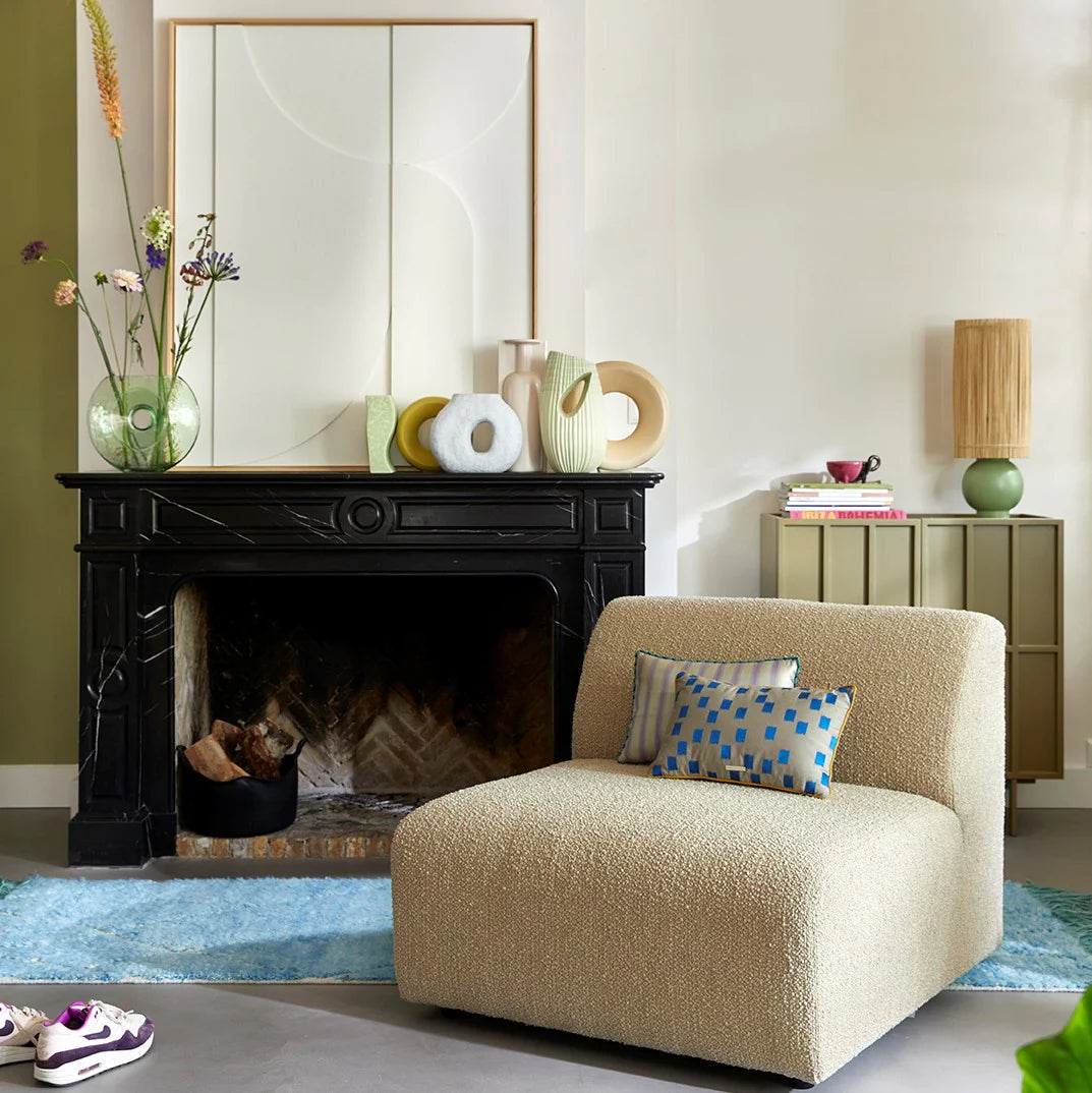 fireplace with organic shaped vases, lounge chair with small accent pillows white avstract painting