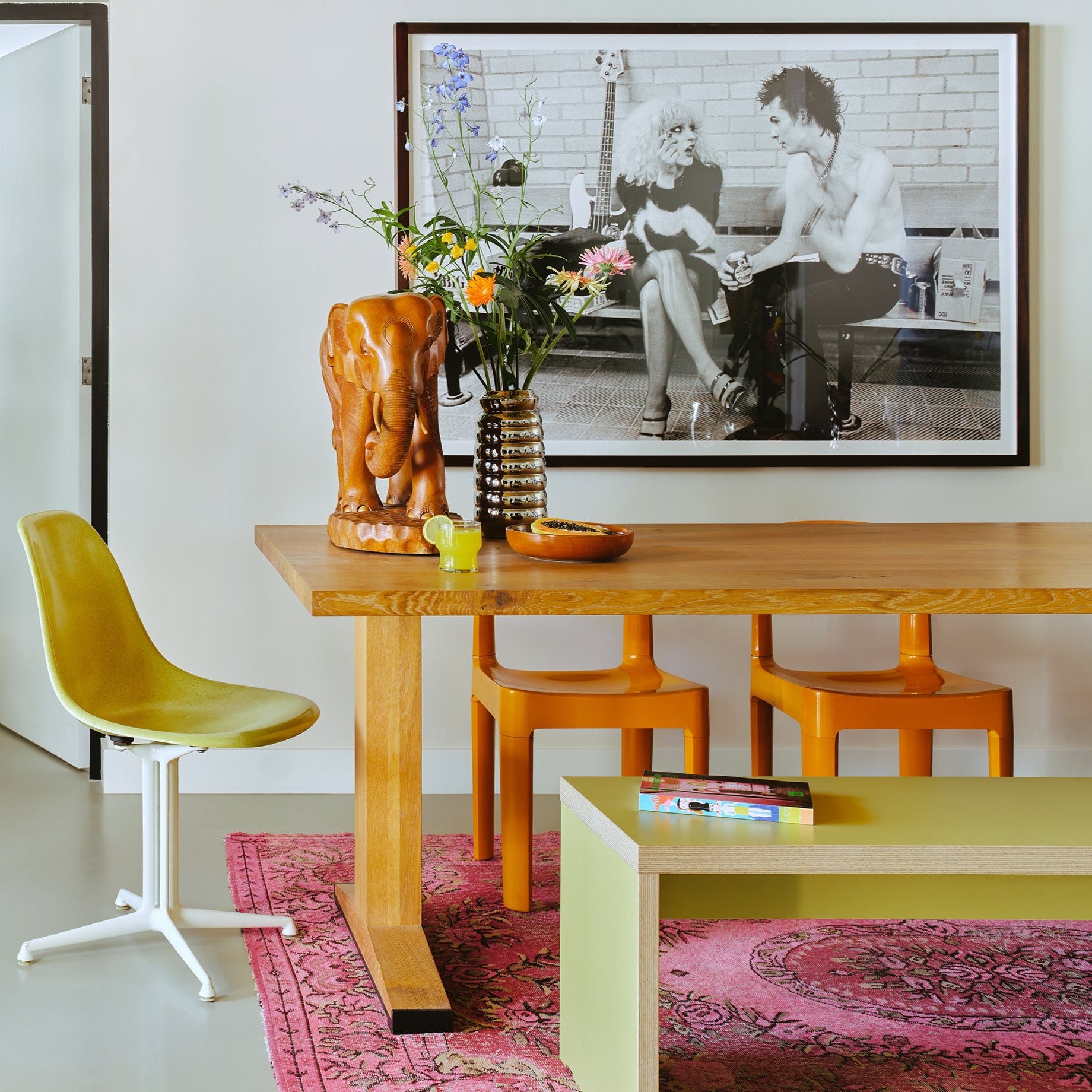 wooden table with chrome vase and wooden sculpture of eliphant. Black and white art print Sexpistols Sid and  nancy