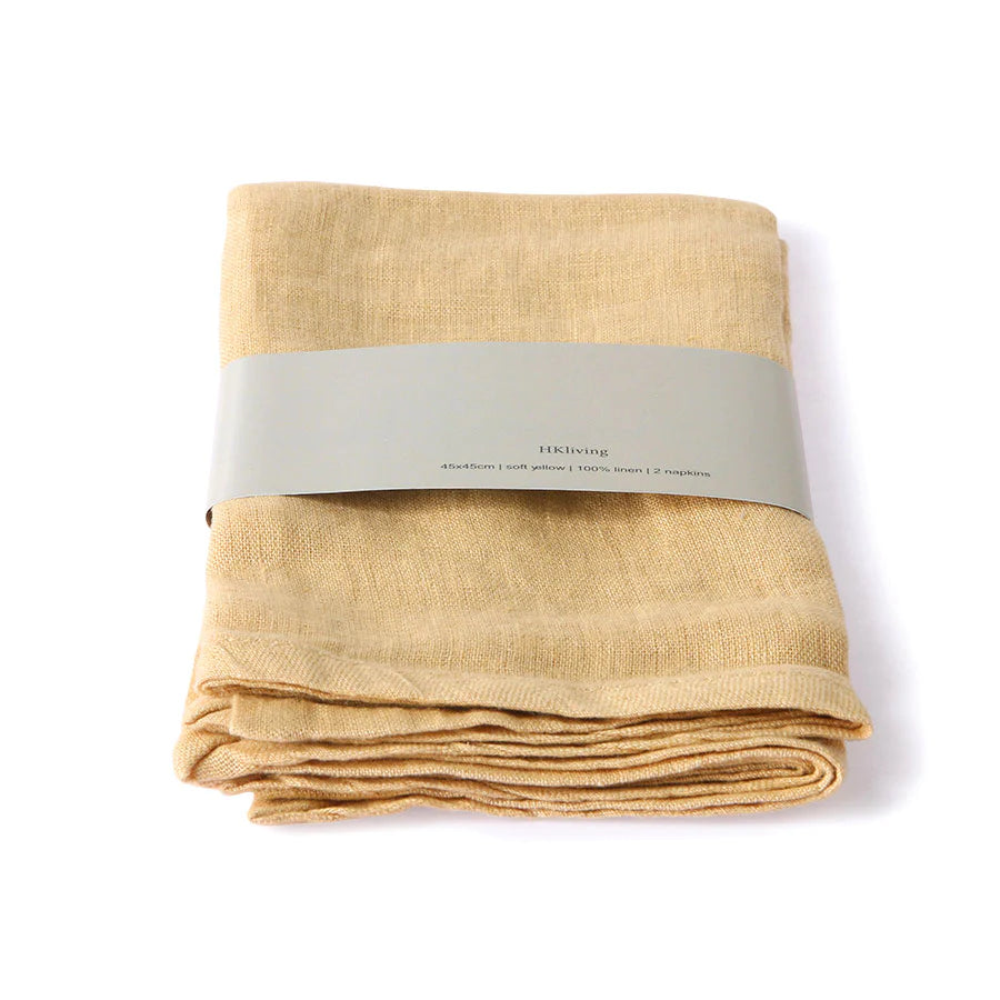 2 folded linen napkins yellow colored with grey carton