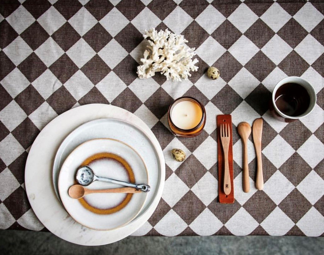 brown and white checkered traditional Dutch table cloth with tableware and wooden cutlery 