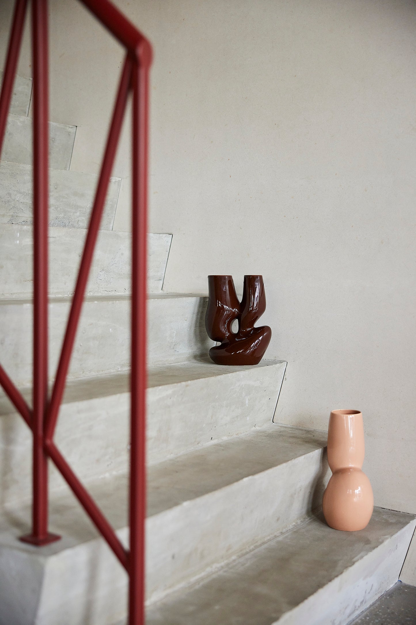 espresso brown organic shaped flower vase on concrete stairway