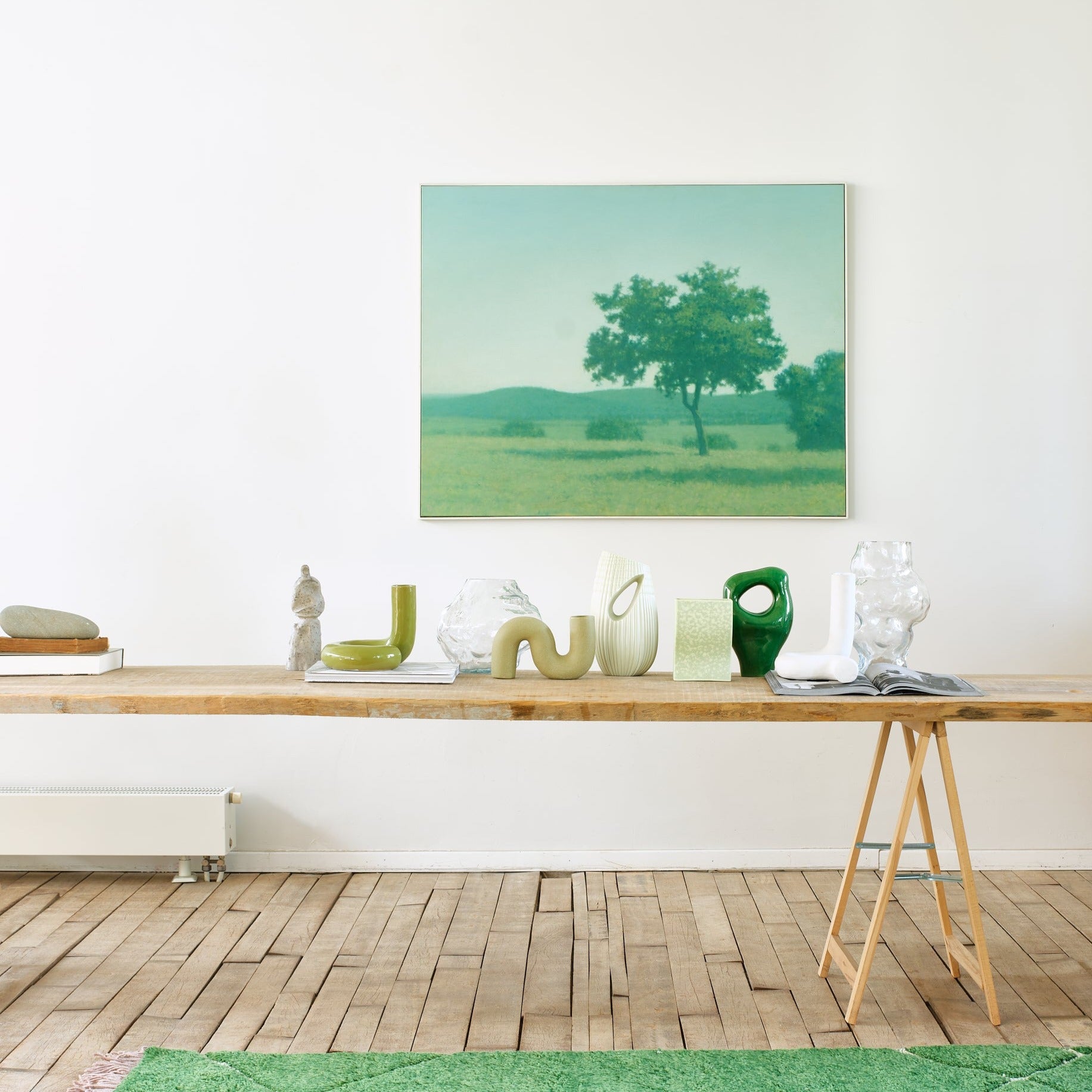 green objects and vases on a wooden trestle table