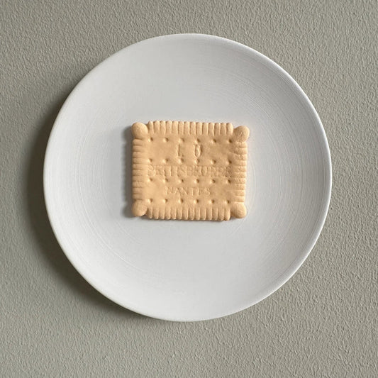 Square cookie on a white plate against a gray background