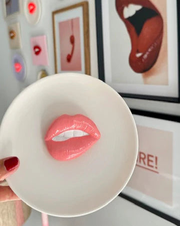 Lip-shaped object on a white plate with artistic background