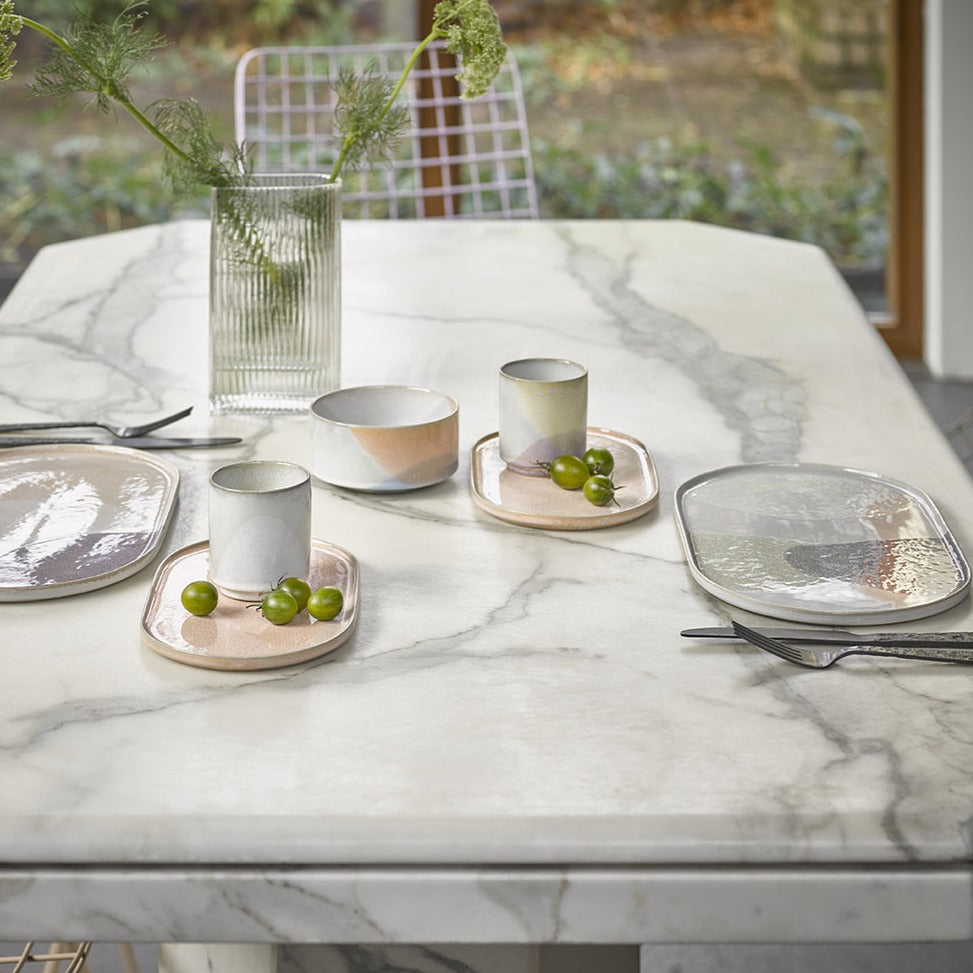 marble table with peach colored oval side plates used as saucers