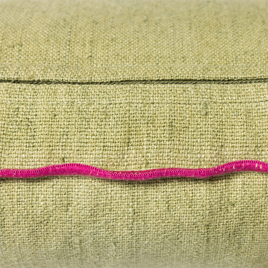 detail of green linen lumbar pillow with pink cotton trim