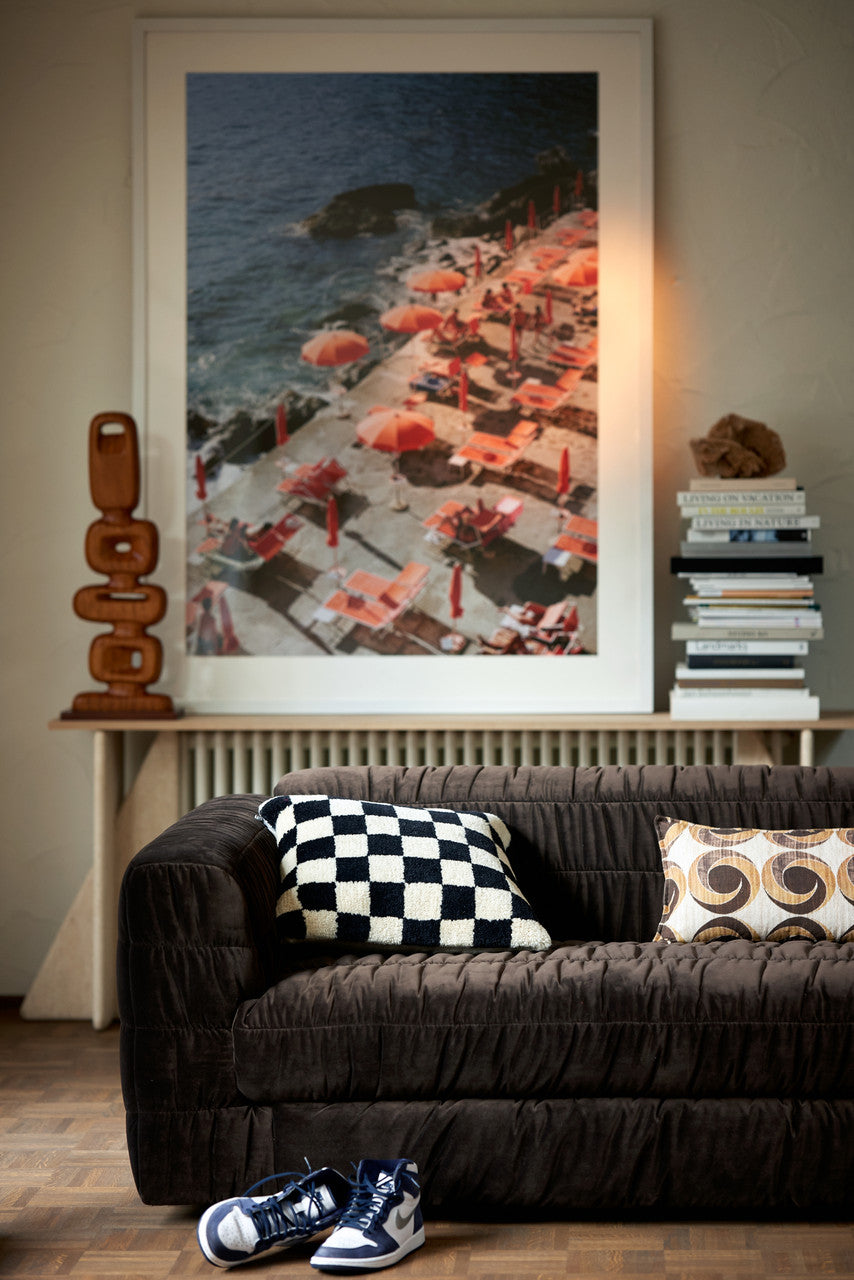 lumbar pillow with brown vintage circles on brown sofa with black and white pillow and large framed photo