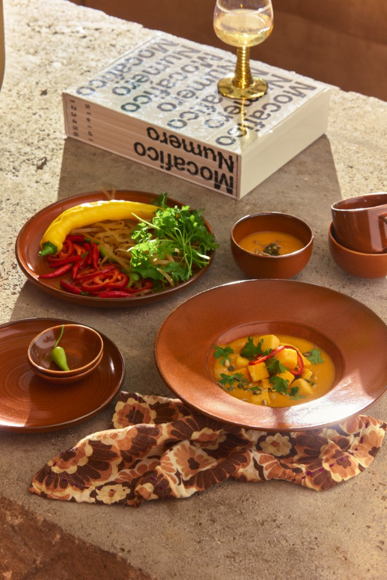 burned orange tableware with food and napkin