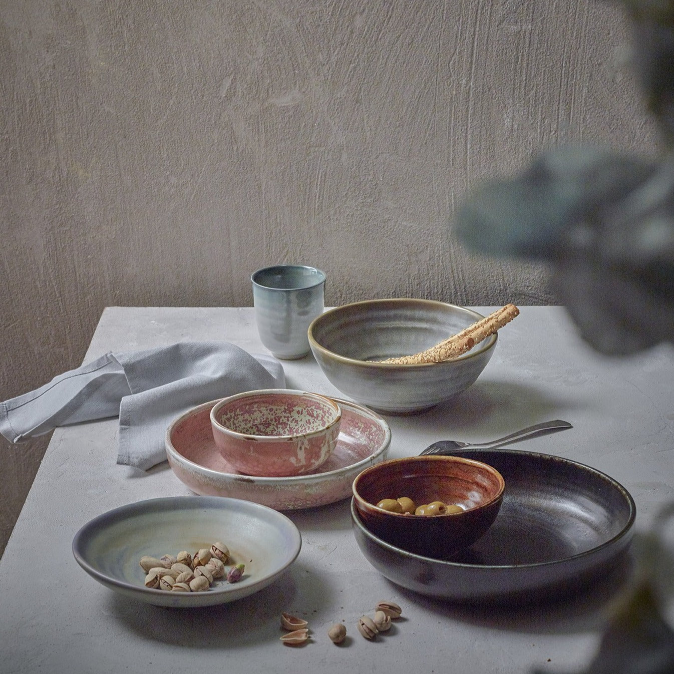 table setting with pink, purple and black ceramic plates and bowls
