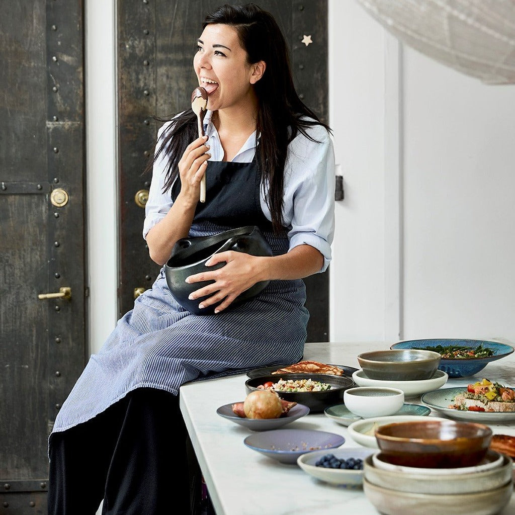 home chef in kitchen with ceramics on countertop 