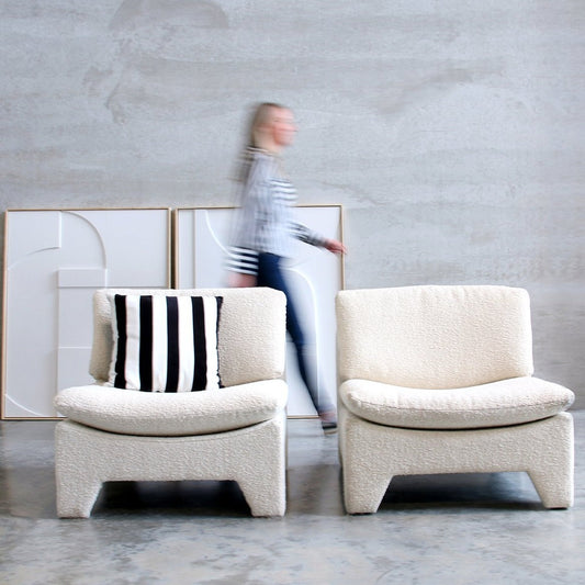 retro style lounche chairs in white cream color with paintings on wall