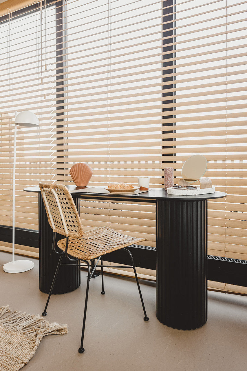 large window with shutters, black console table, natural rattan desk chair and a mirror with stand made from natural wood