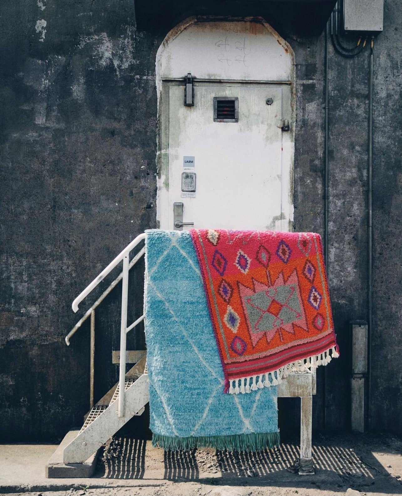 pink woolen rug runner and a blue area rug in industrial area