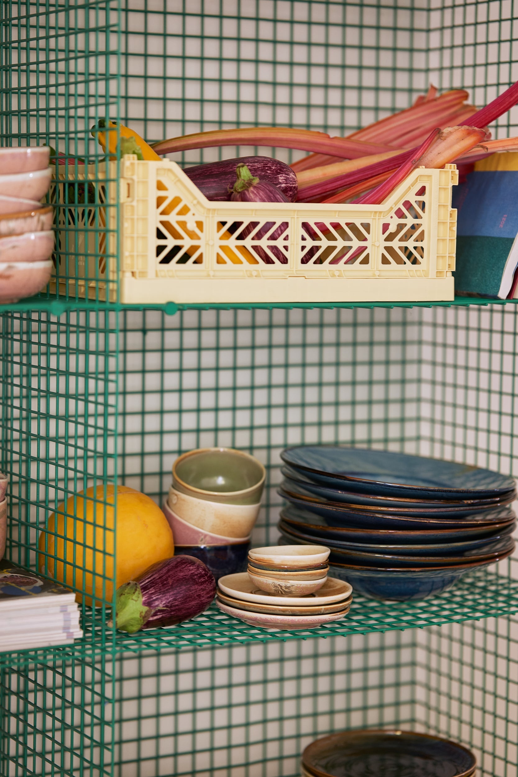 small flat condiments bowl stacked in a green open shelving  pantry 