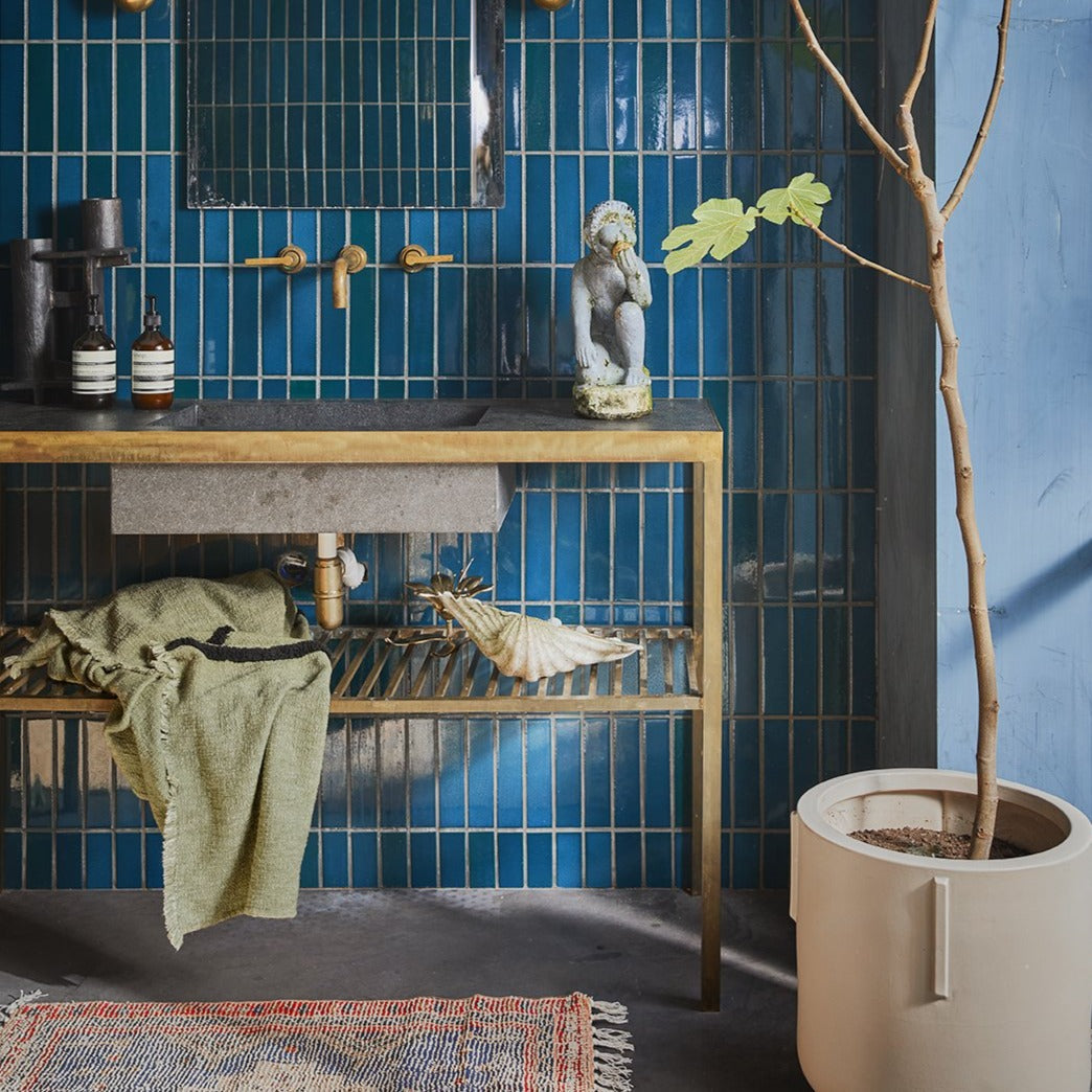 bathroom with blue tiles and pistachio green soft woven throw blanket 