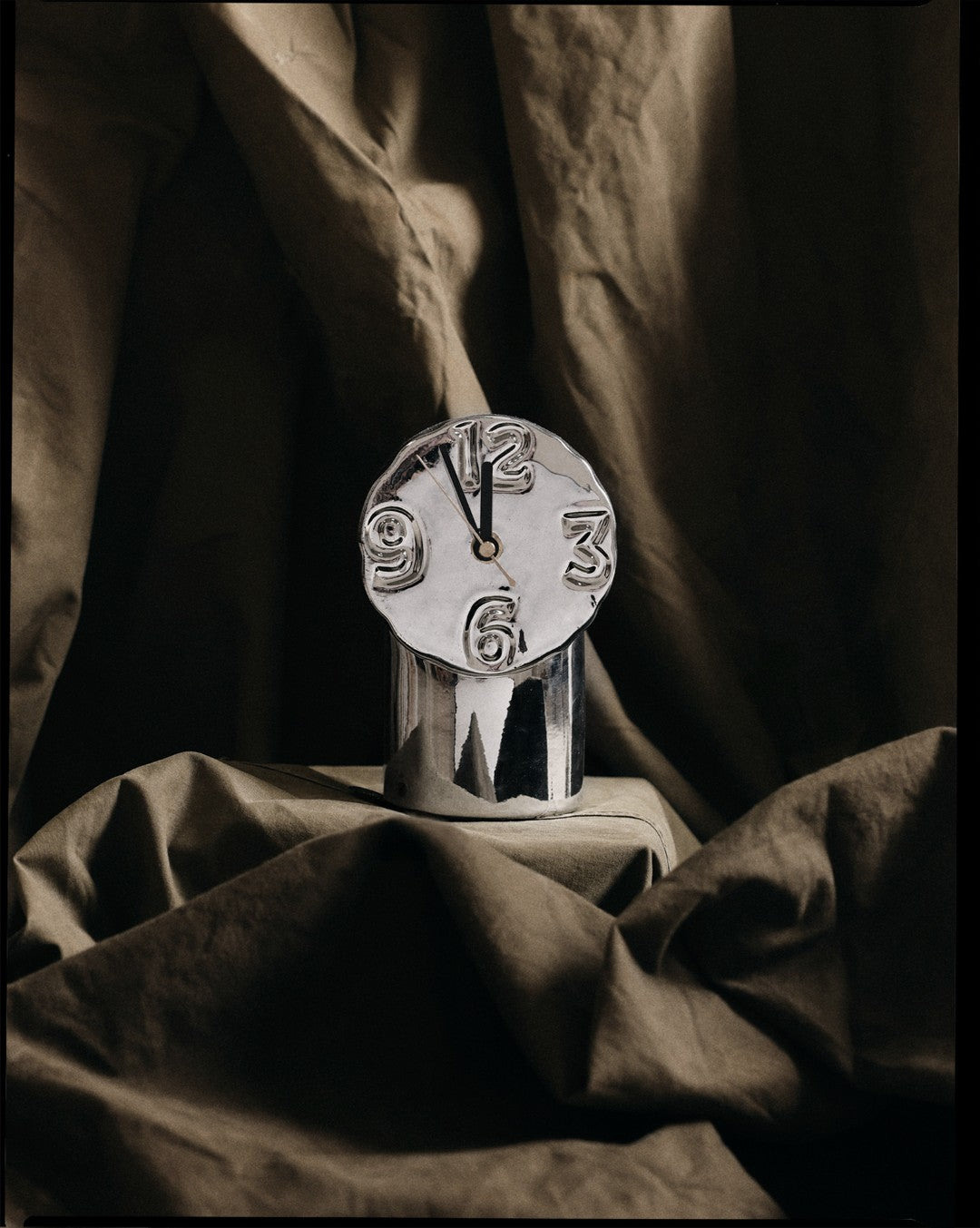 chrome colored table clock with brown cloth