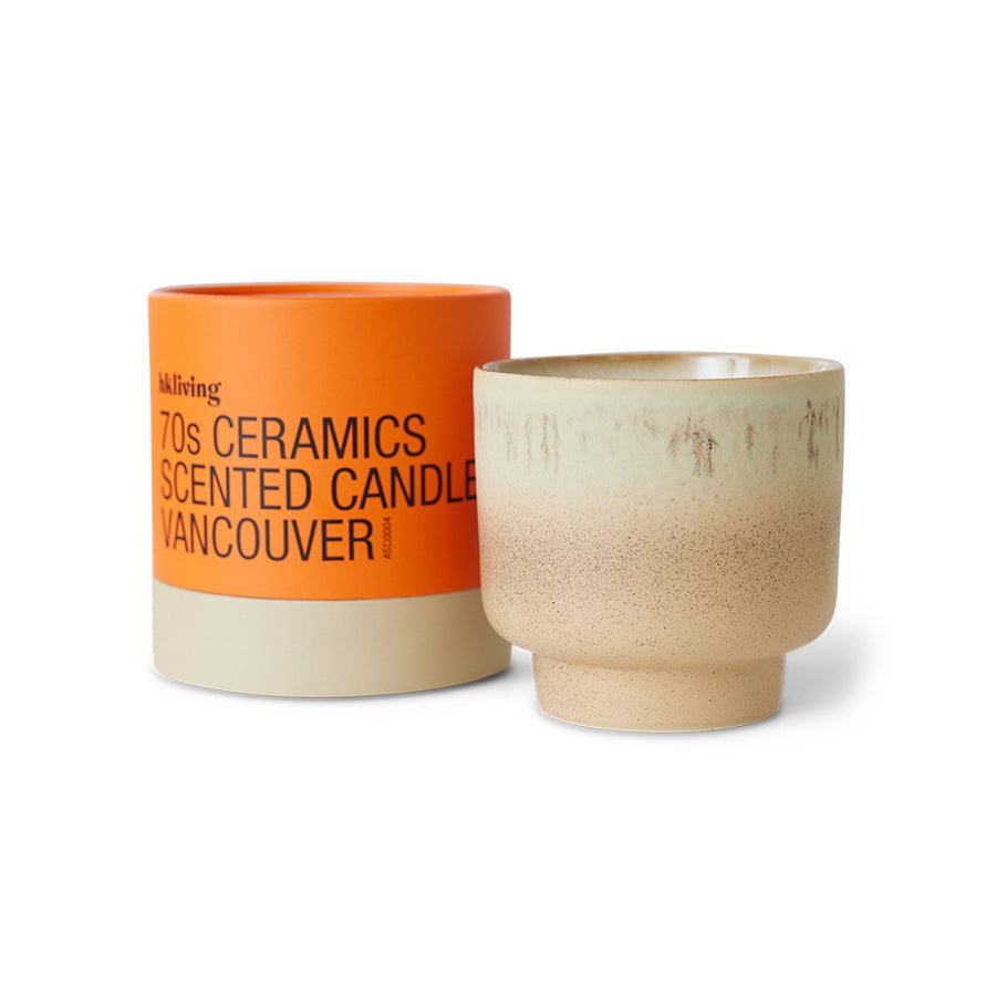 Ceramic candle with orange lid and beige body on a white background