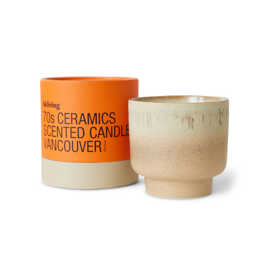 Ceramic candle with orange lid and beige body on a white background