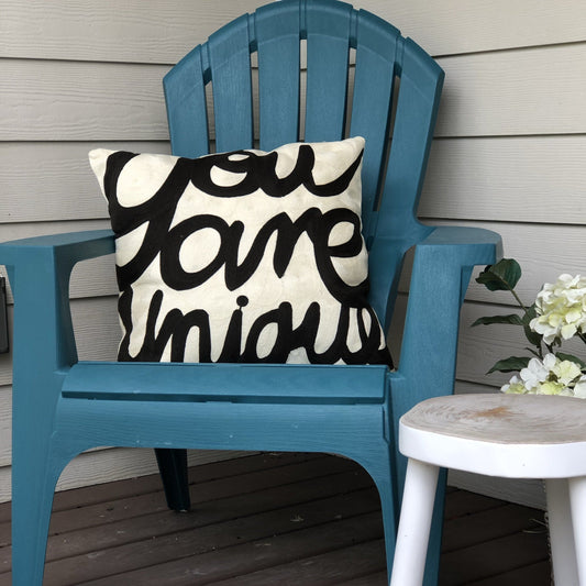 black and white throw pillow in blue Adirondack chair