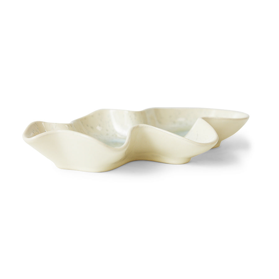 White ceramic dish with a wavy edge on a white background