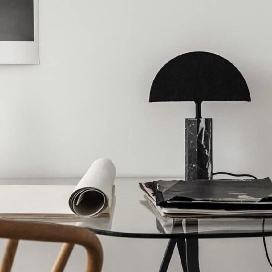 desk with a table lamp with black marble base and half moon shaped shade.