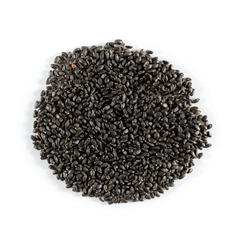 Pile of black basil seeds on a white background