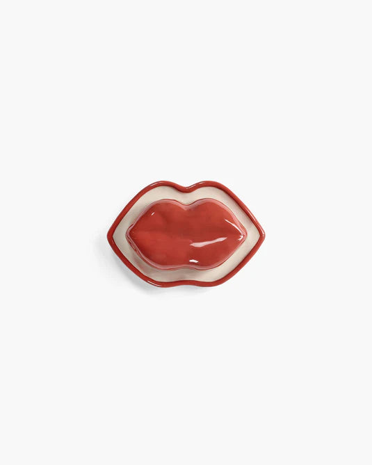 Red lip-shaped dish on a white background
