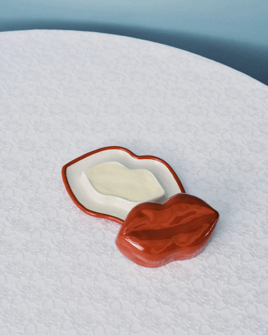 Red and white container on a textured surface with a light blue background