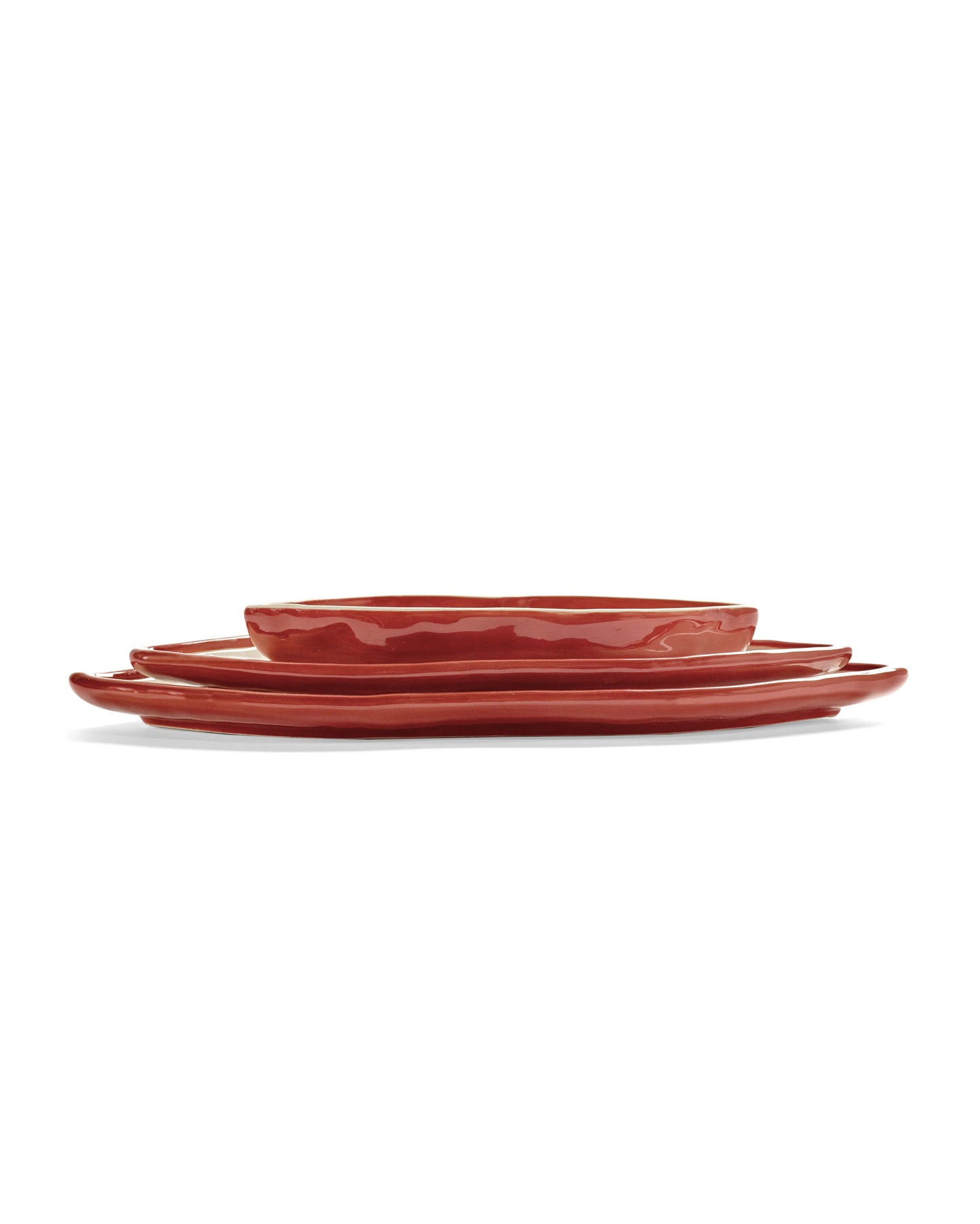 Set of three red ceramic plates on a white background