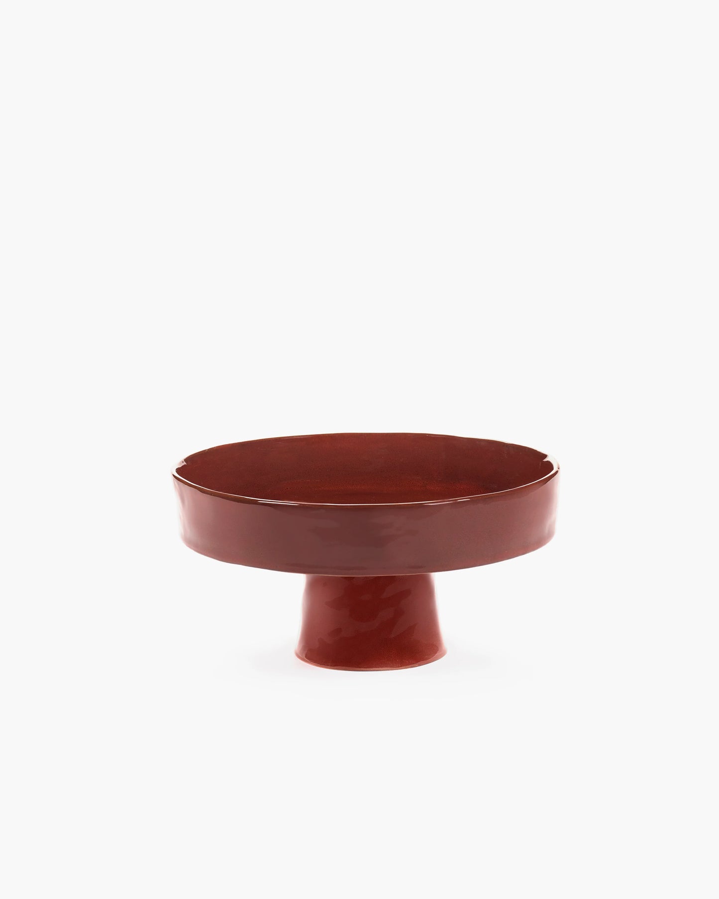 Red ceramic footed dish on a white background
