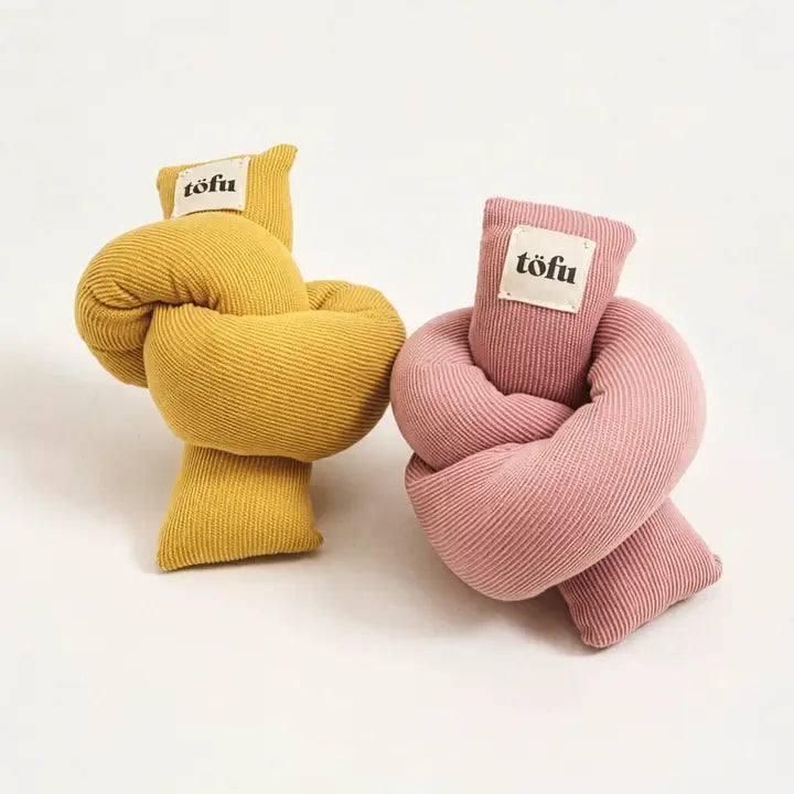 two knotted corduroy cat toys in yellow and pink with label on a white background
