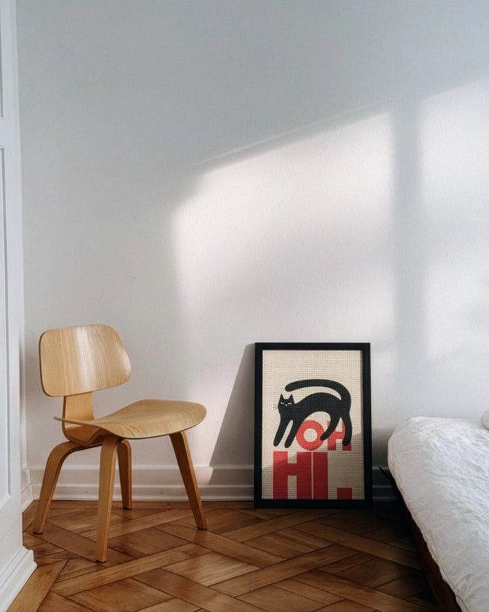 framed wall scratcher with oh hi text and black cat in room with chair