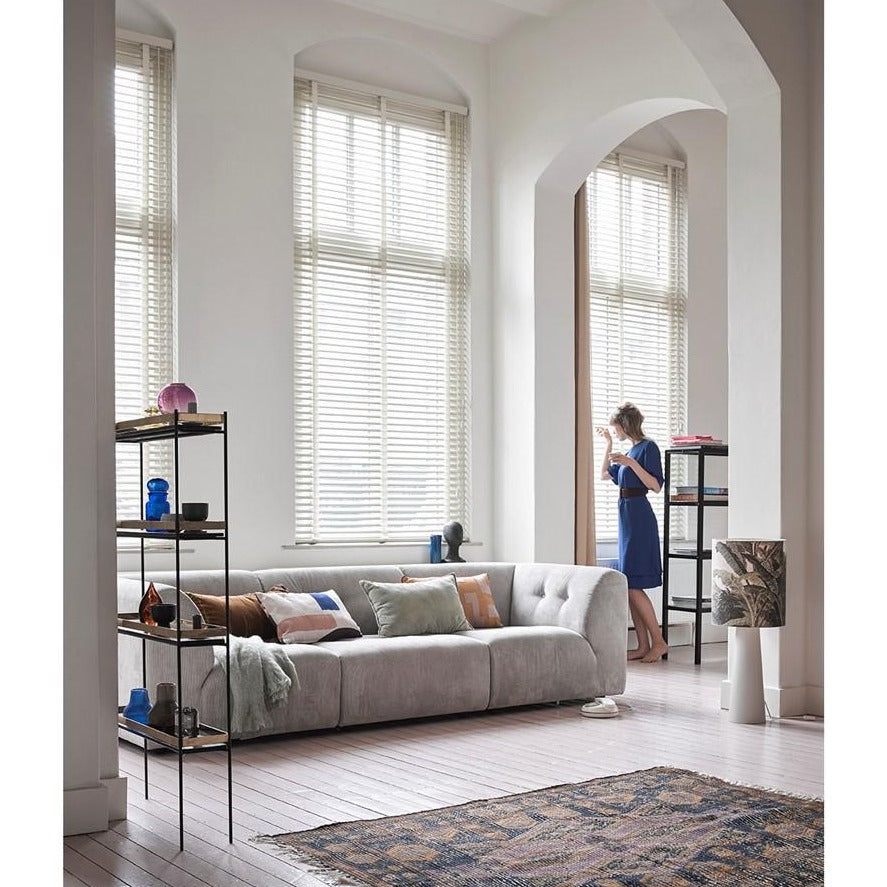 large table lamp with printed jungle design and grey base on floor in living room with woman eating a bowl of cereal