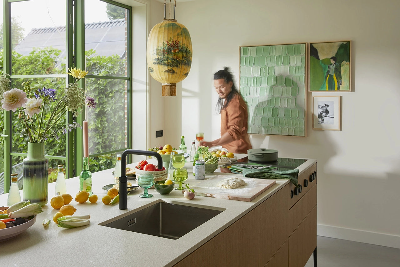 kitchen island filled with lemons and glassware and a green abstract palette painting on the wall