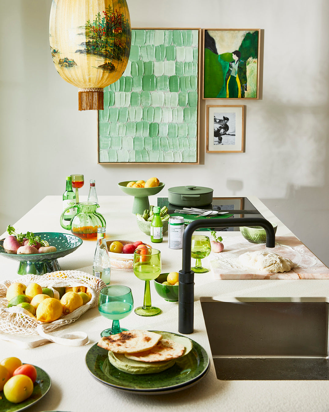 kitchen island with green colored server ware and art works on the wall