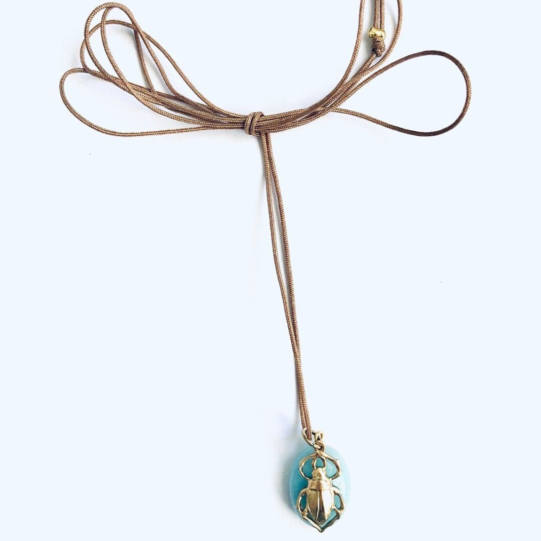 hanger of brass beetle on a blue stone