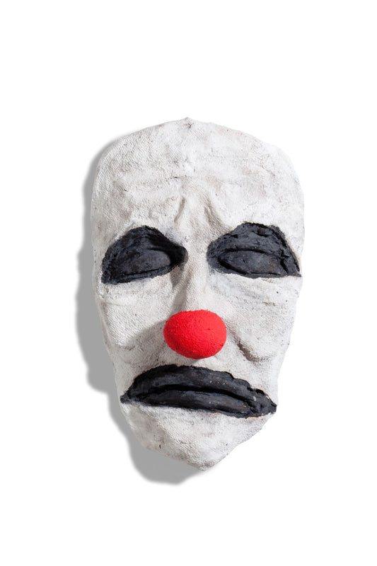 bronze sculpture of face of a clown in white red and black