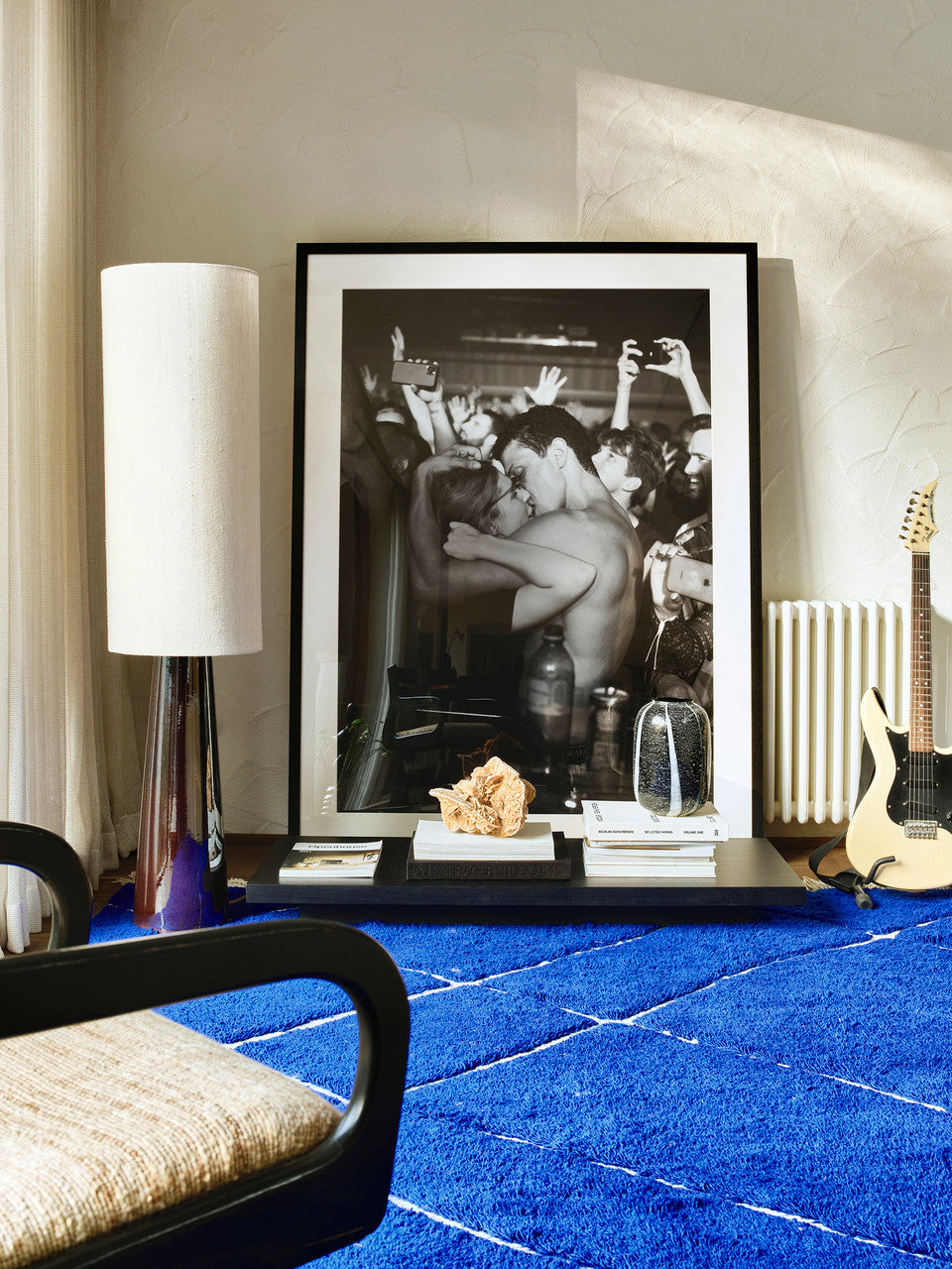 black and white photo of boy and girl kissing at festival, framed in black frame in living room with blue 