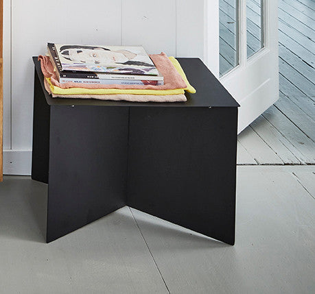detail of black metal side table with magazines