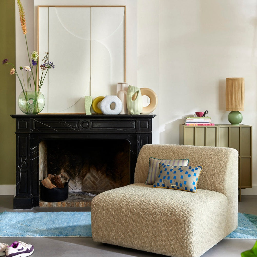 lounche chair in front of fire place filled with silk pillows