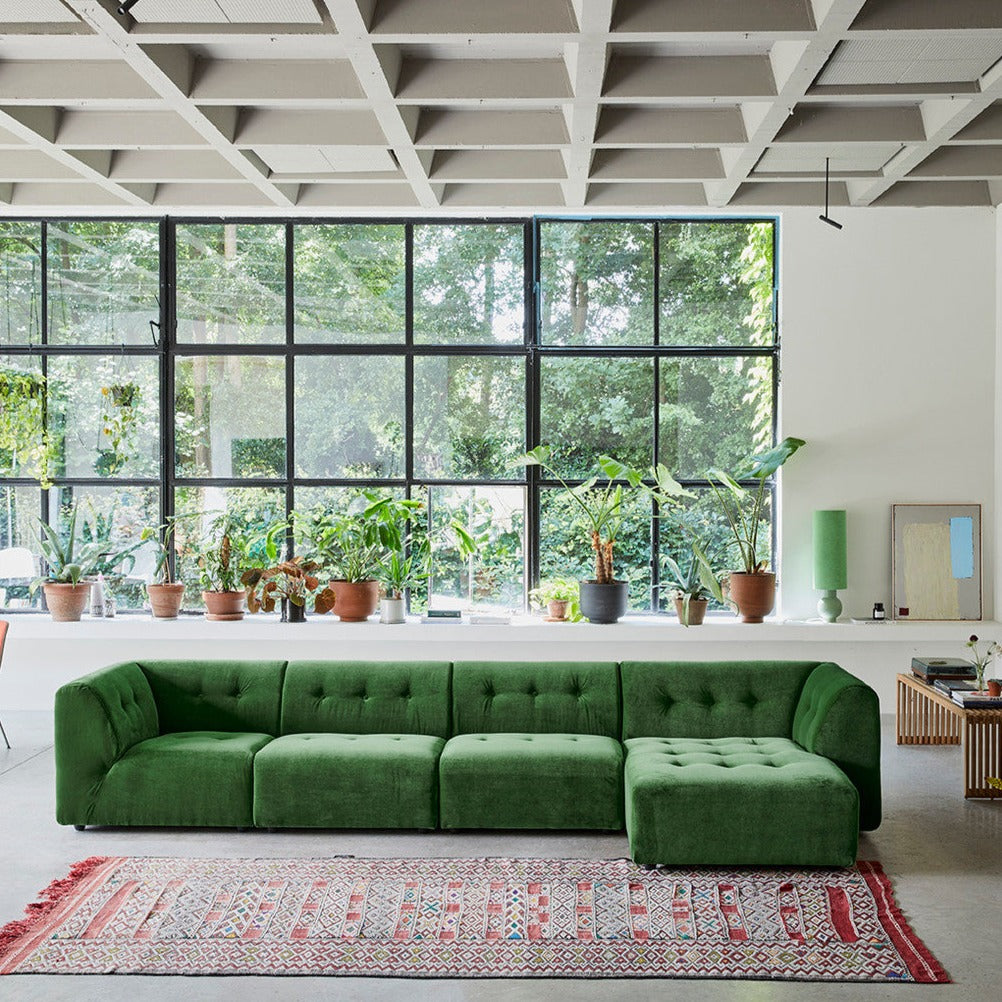 green element sofa in front of large window