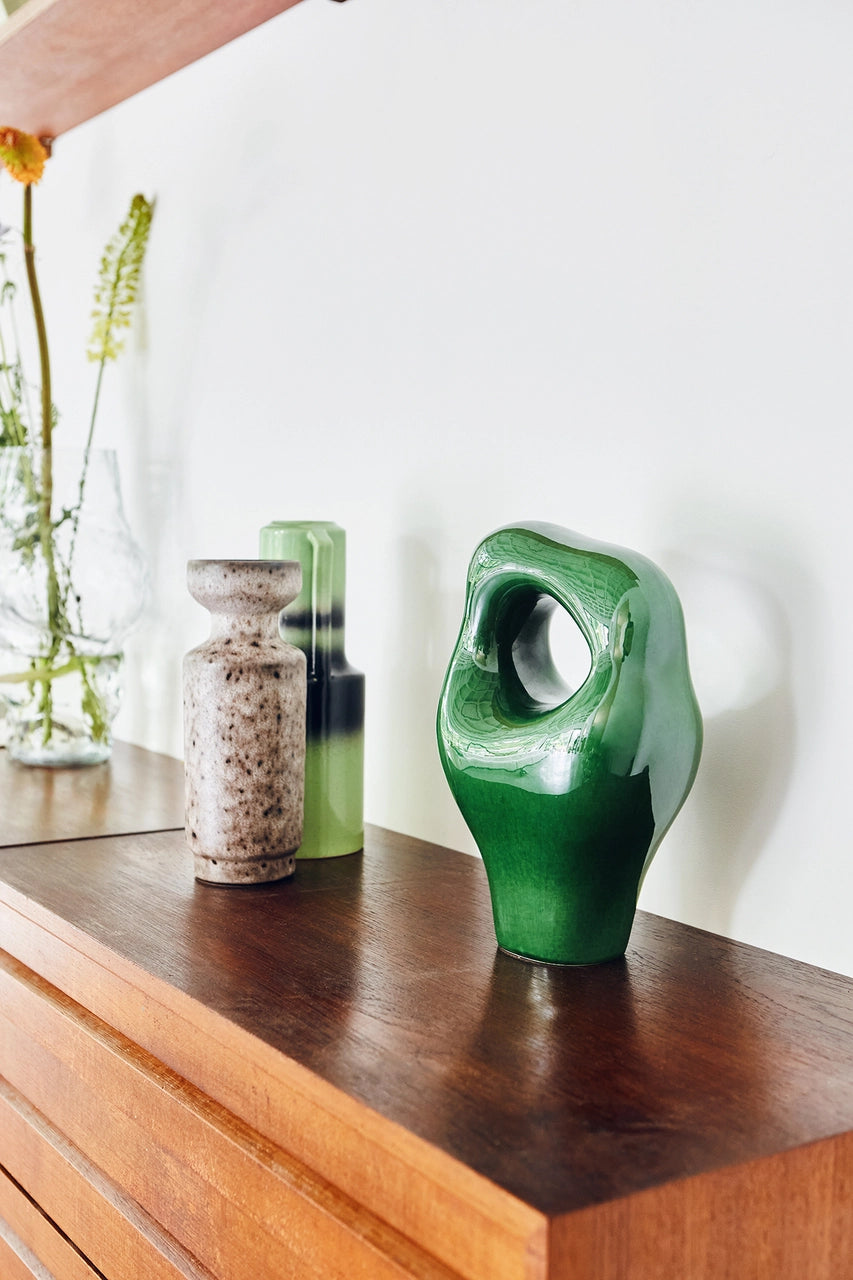 green glssy artsy object and two retro style vases